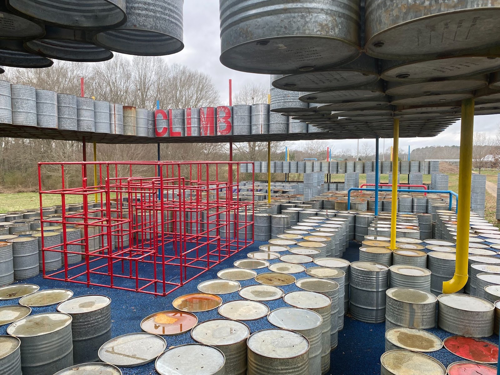 A playground made out of oil drums set into the rubbery bottom typically found on children playgrounds. 