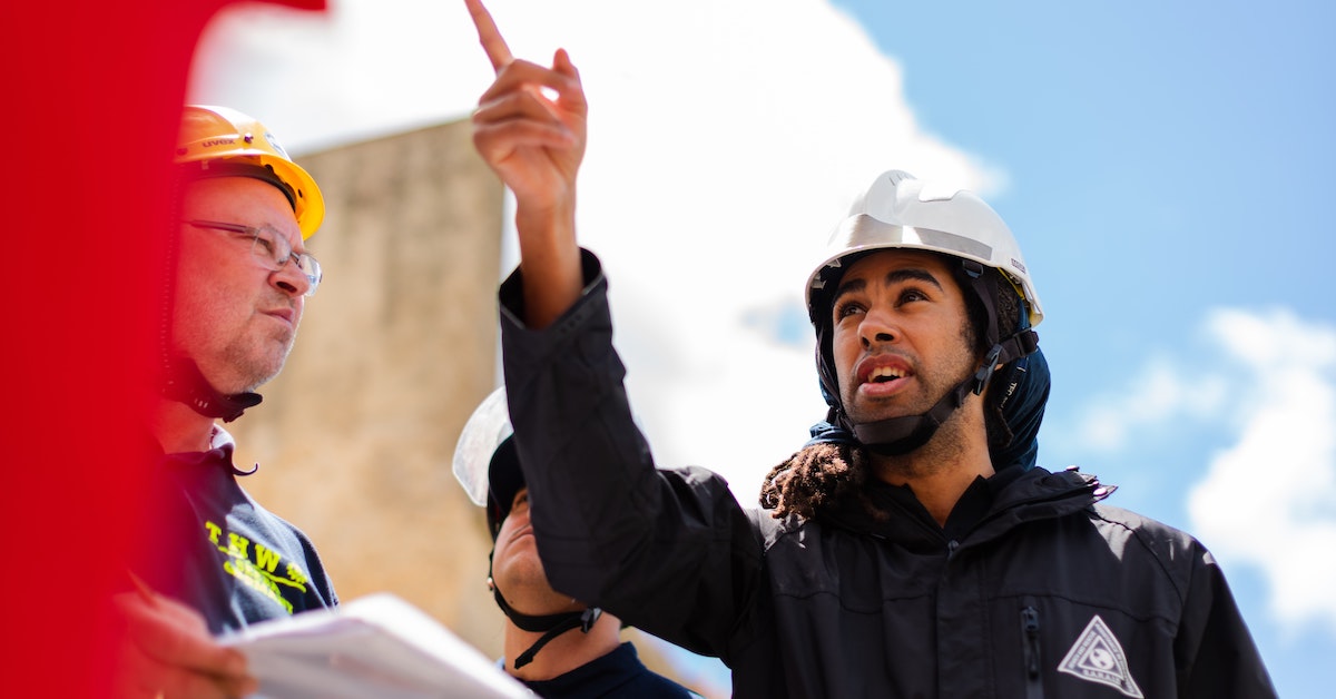 Building engineer pointing out to pother builders