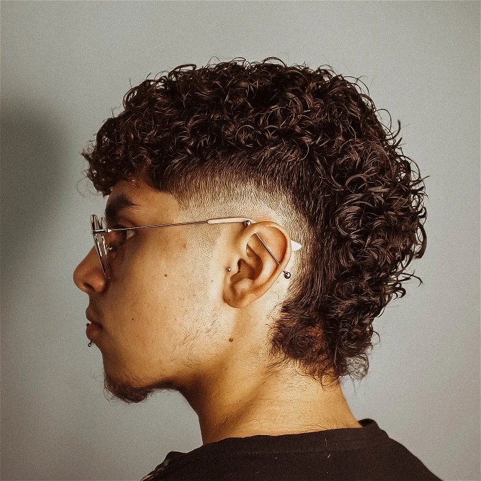 Side view of a man rocking a curly hairdo