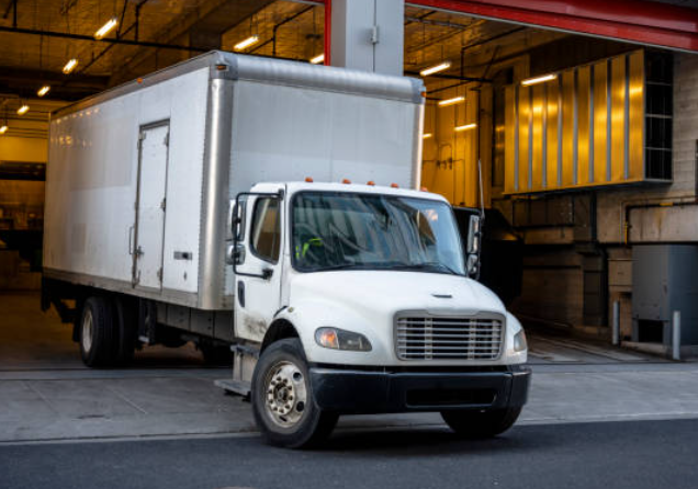 White box truck leaves warehouse