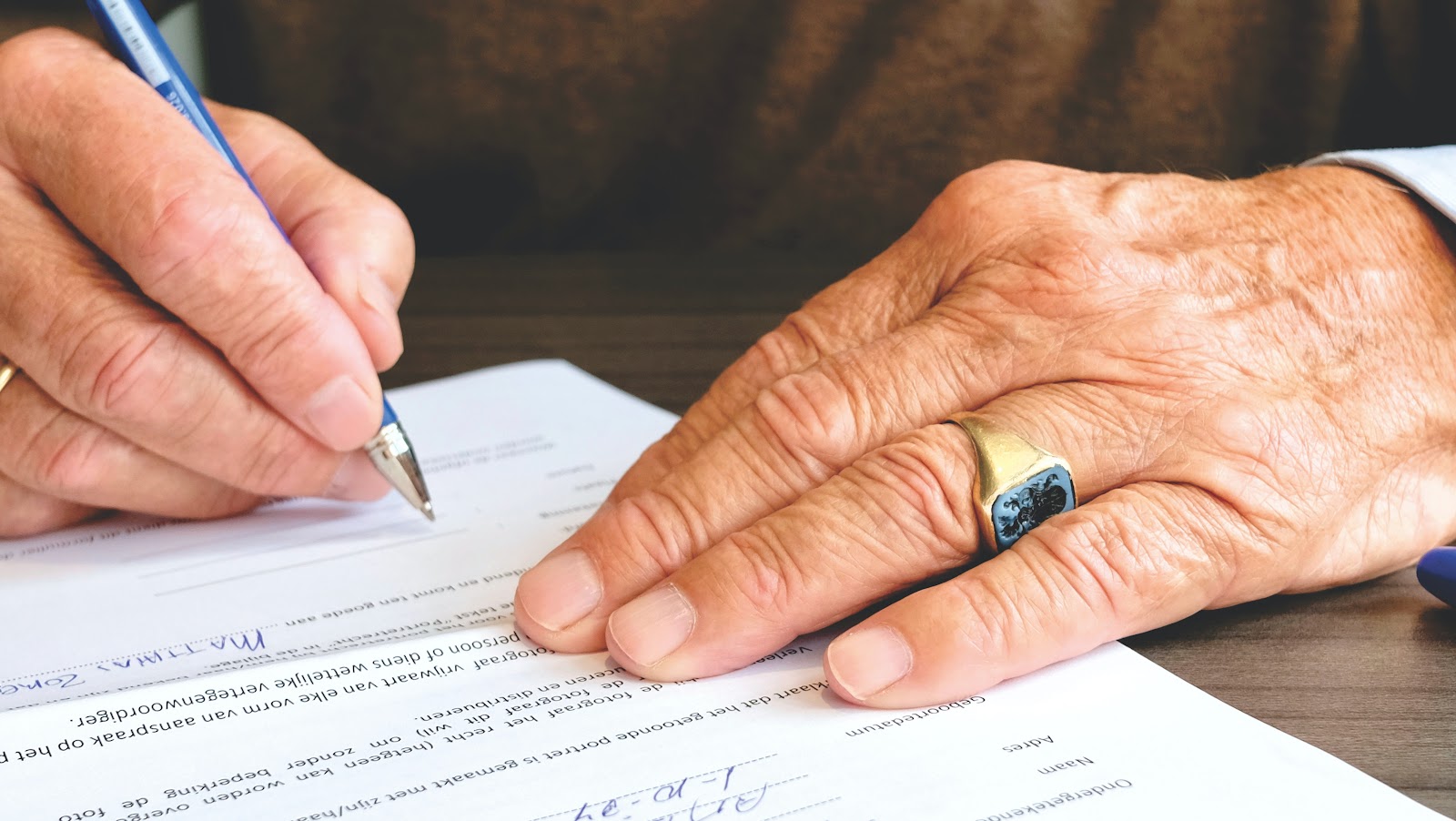 a man signing a contract to start a Wells Fargo career
