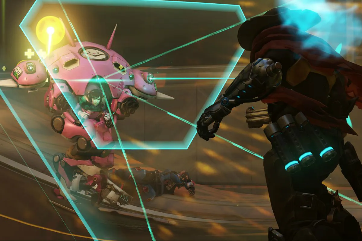 Tank Hero D.Va z Overwatch 2 nasadí svoju obrannú maticu, aby zablokovala útok poškodenia hrdinu Cassidy