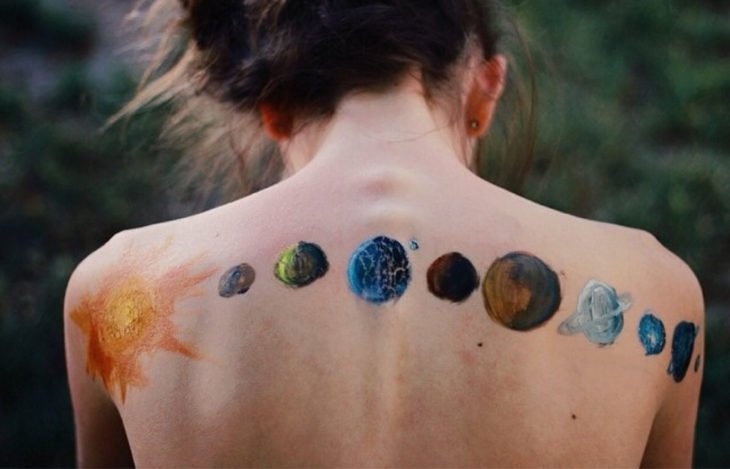 tatuagem de planetas nas costas da mulher
