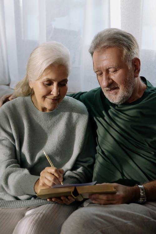 Free Man in Gray Sweater Sitting Beside Woman in Green Sweater Stock Photo