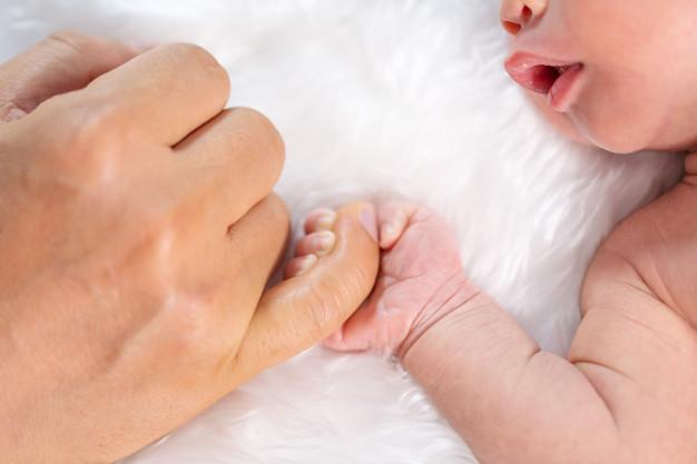Premium Photo | Newborn baby boy holding little finger of father's hand