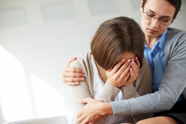 Mujer triste llorando junto a su terapeuta Foto gratis