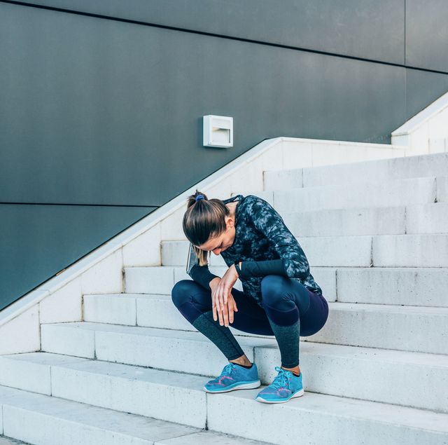 exhausted runner resting on the stairs after exercise