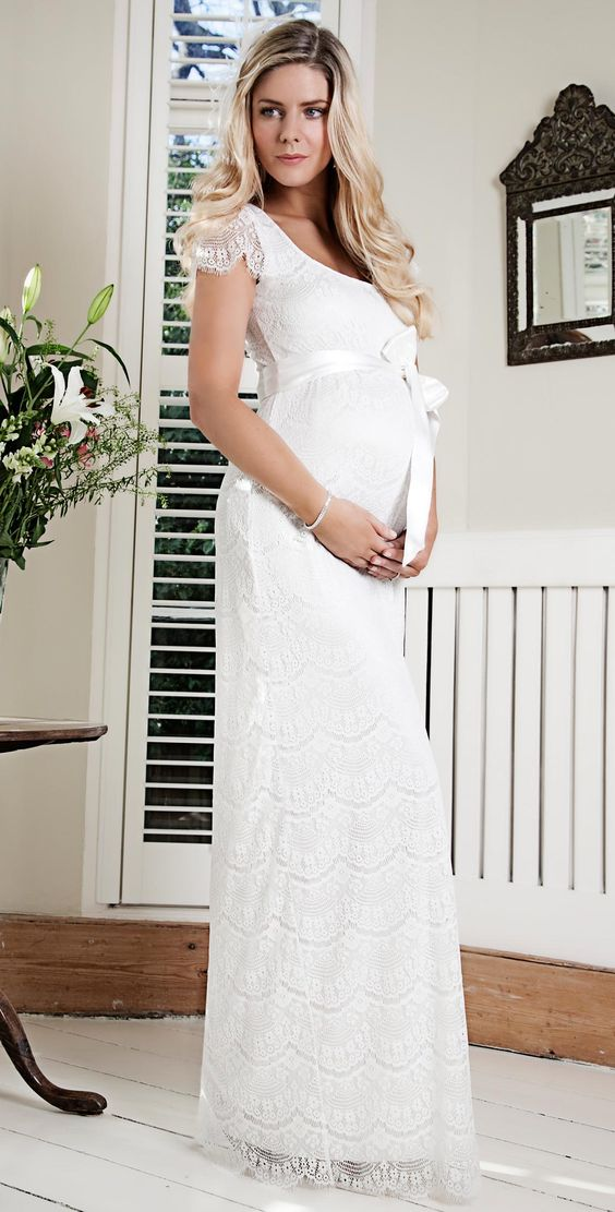 A bride wearing a sheath wedding gown with belt