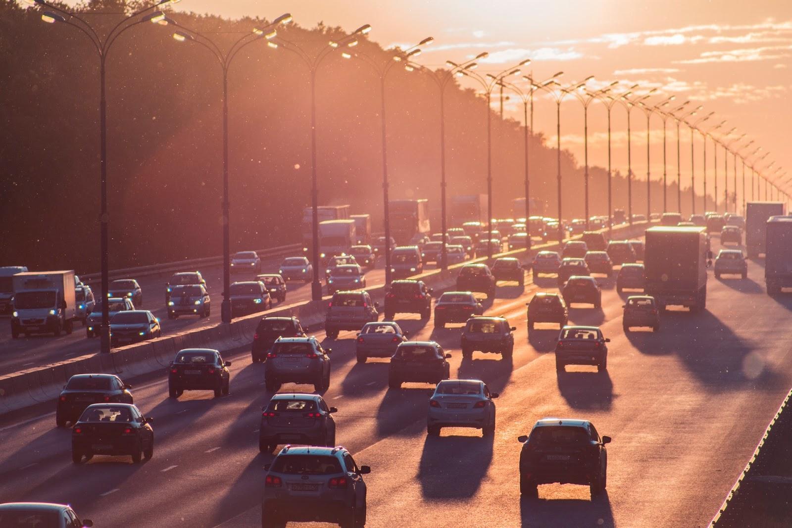 La imagen muestra una carretera llena de autos. Se pueden ver seis carriles de un lado, donde los autos están de espalda a la imagen. En la esquina izquierda hay más coches que se ven de frente.