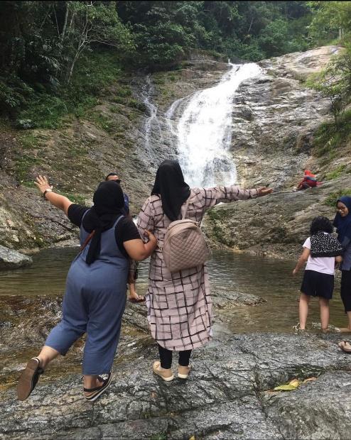 A group of people standing next to a waterfall

Description automatically generated