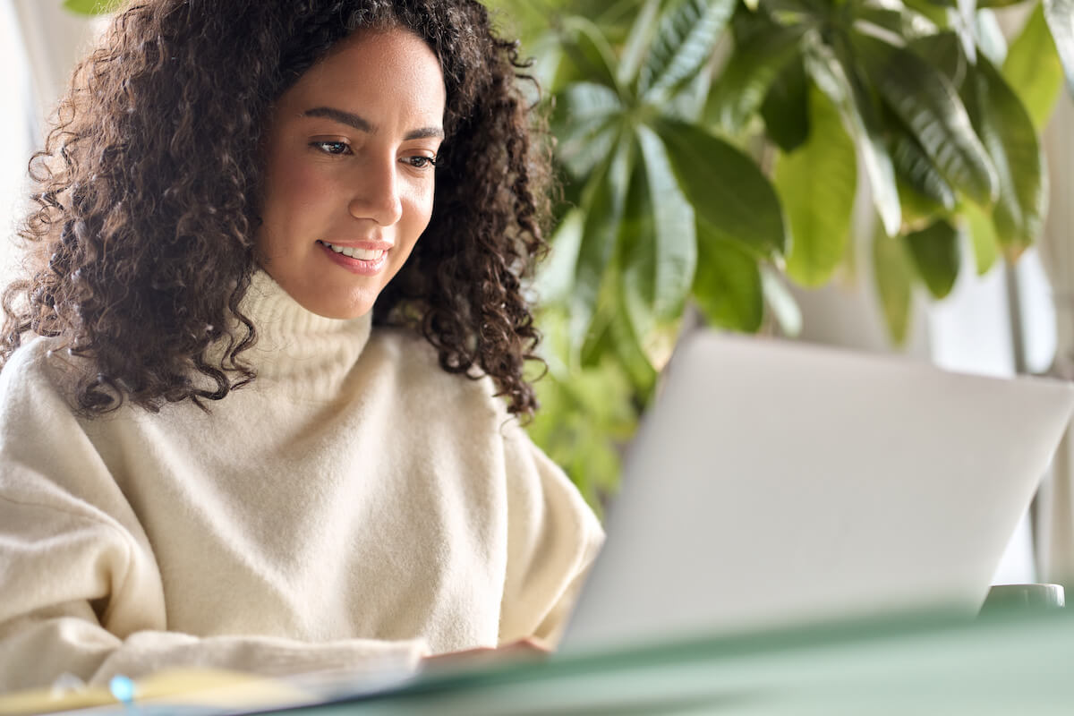 Curly-haired entrepreneur using a laptop