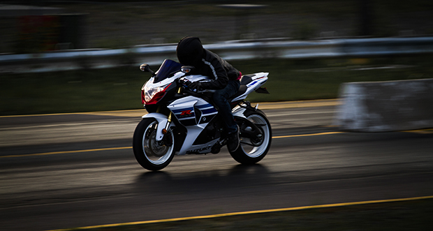 Photo taken with panning method of a motorcycle. Motorcycle and the driver are clear, but the background is blurred.