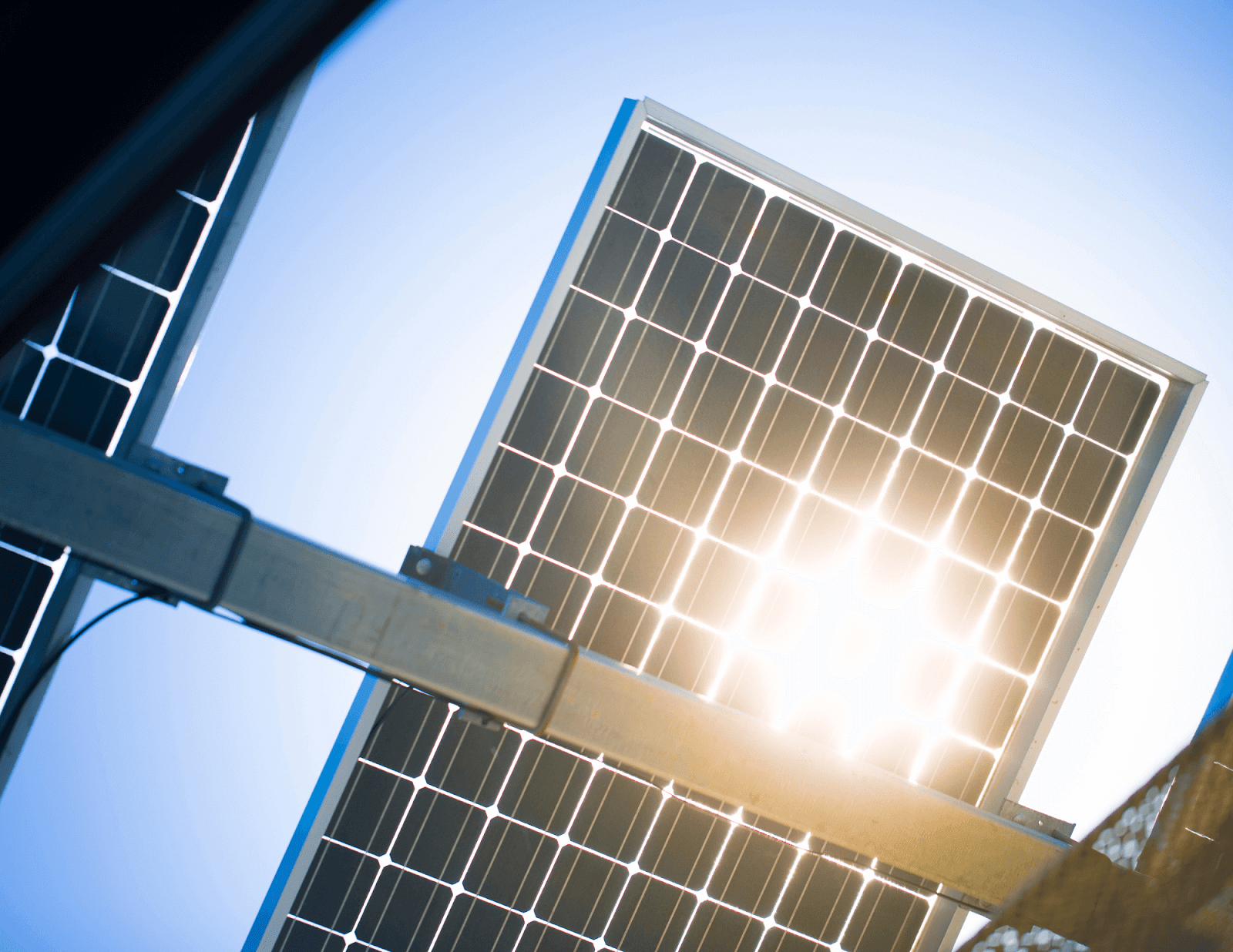 Image of a solar panel looking from beneath with sun shining through. 