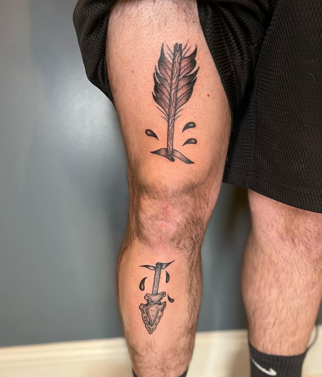 arrow through knee tattoo