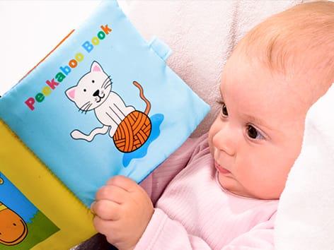 baby playing with soft books