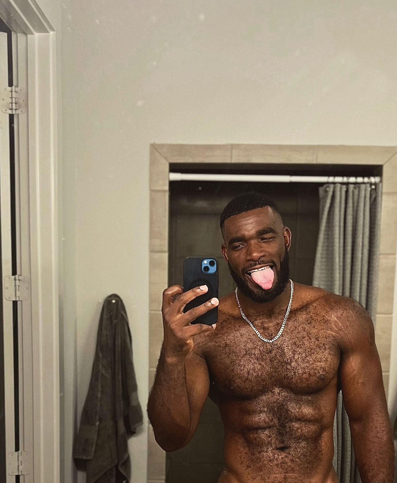 Marshall Price sticking his tongue out while taking a gay shirtless mirror selfie for his Onlyfans subscribers