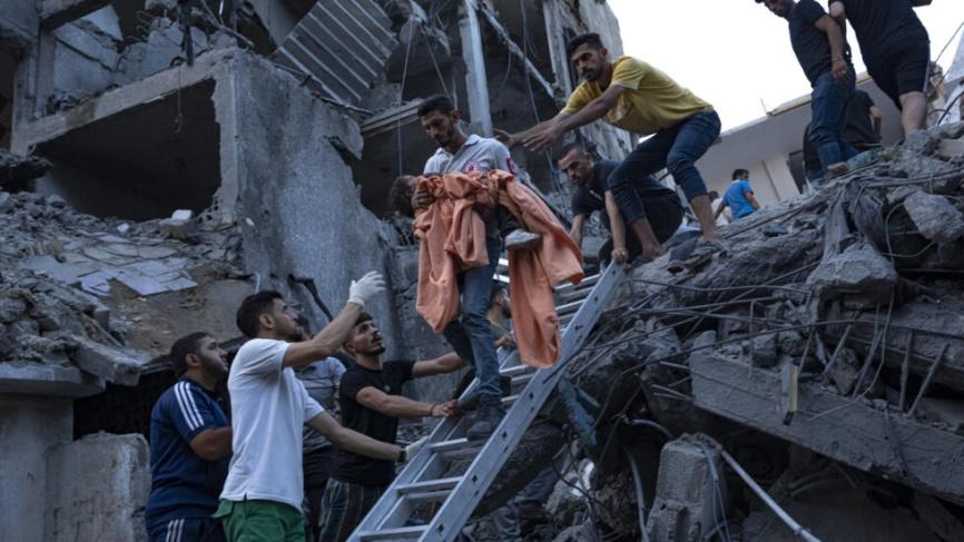 Dân Palestine cứu một bé gái khỏi một tòa nhà bị phá hủy trong một vụ oanh kích của Israel vào Gaza ngày 10/10/2023.
