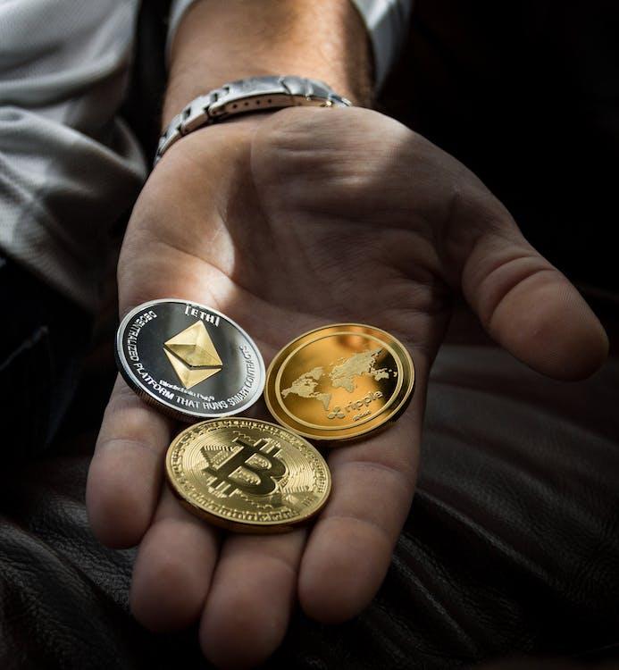 бесплатная Крупным планом фото трех круглых монет на ладони человека Стоковое фото