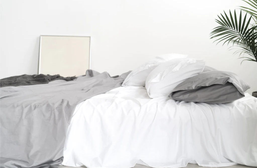 Bed with gray and white sheets