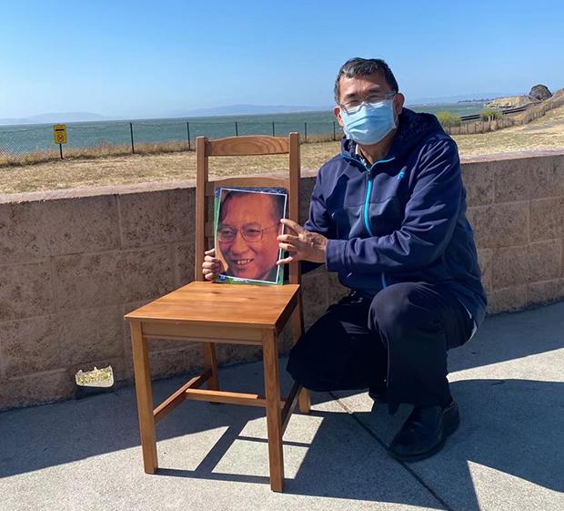 2021年7月13日下午赫拉克勒斯海滩上悼念刘晓波的活动，活动参加者与空椅子合影。（活动参加者提供）