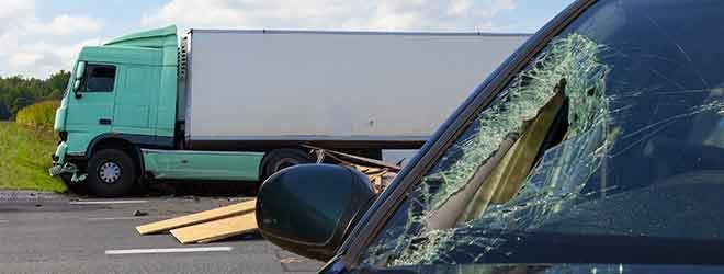 A Rhode Island truck accident attorney documenting the scene of a semi-truck accident. The vehicle's windshield is smashed, and the semi-truck is on the side of the road. 