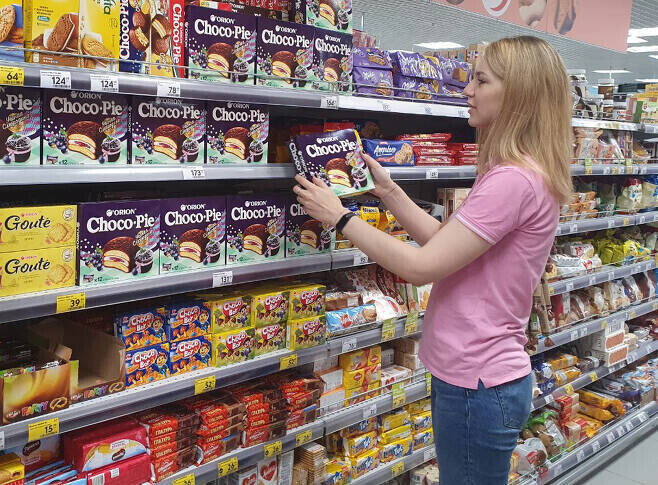 Покупатель в продуктовом магазине в России выбирает коробку Choco Pie. (предоставлено корпорацией "Орион")