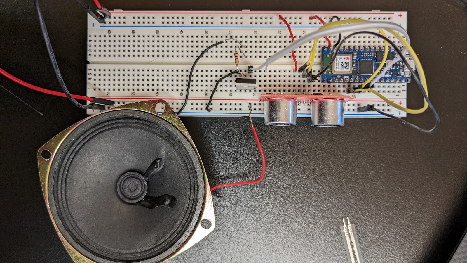 Image of a top-down view of an ultrasonic distance sensor and speaker both connected to an Arduino on a breadboard. 