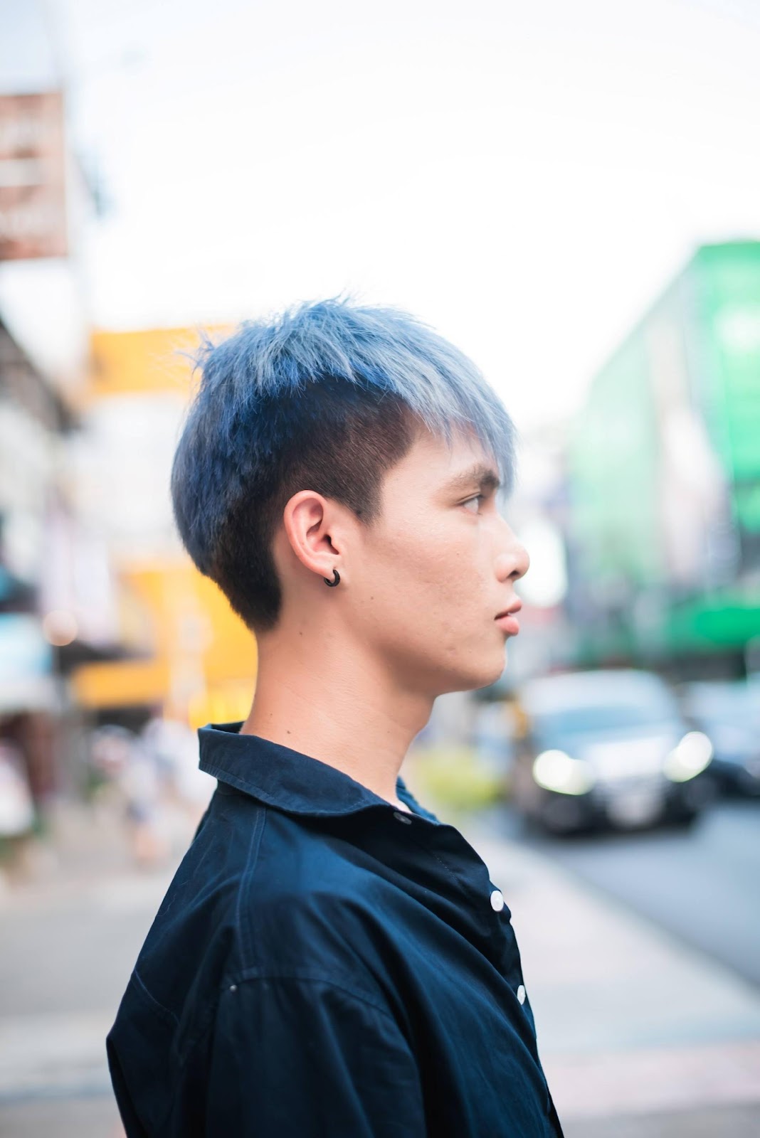 Mặt bên của một người đàn ông châu Á với mái tóc xanh