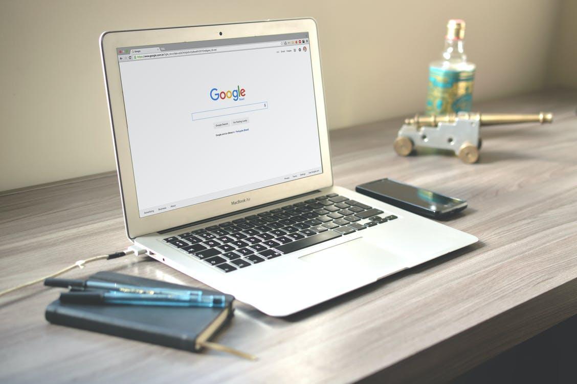 A laptop and notebooks on a wooden table