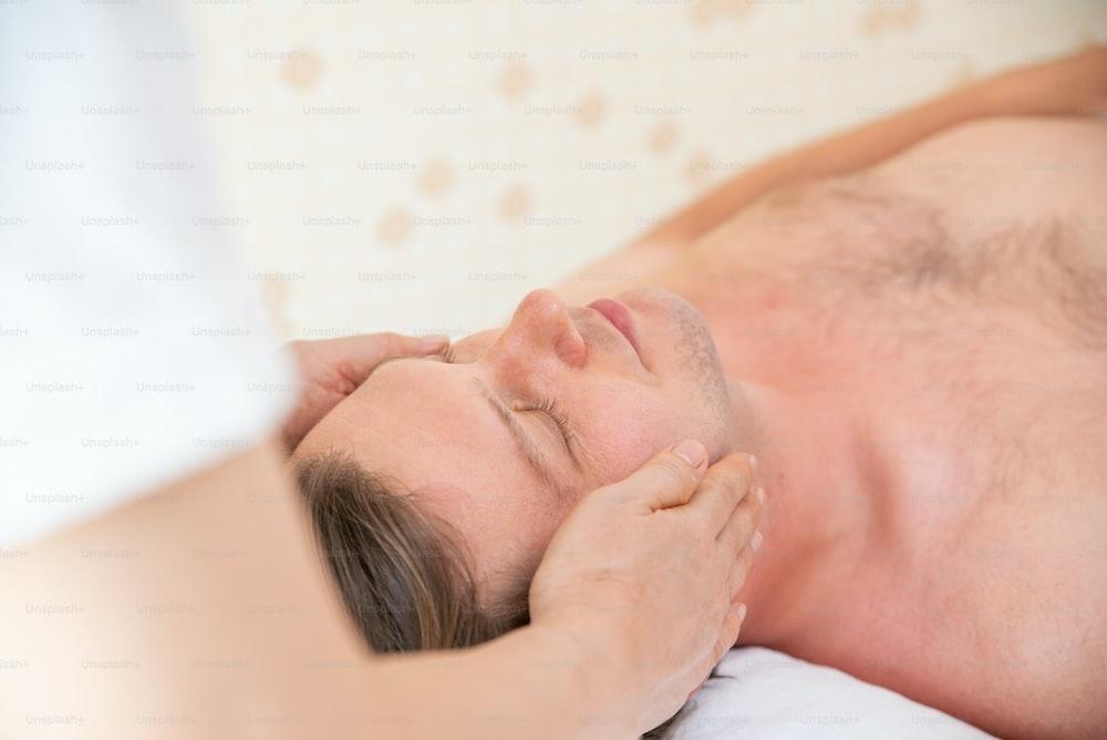 Caucasian man resting on massage bed and get facial spa  treatment with essential oil from professional therapist at beauty salon