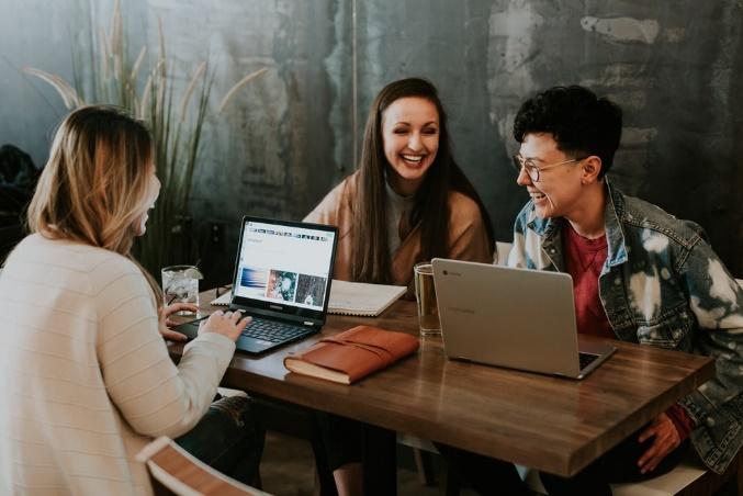 Three students laughing while they work