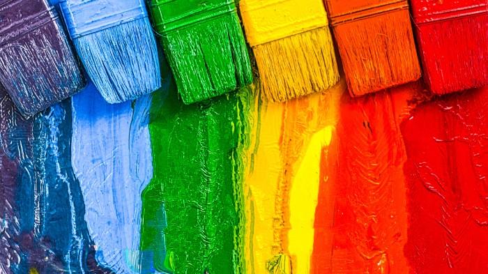 Paint brushes painting a rainbow