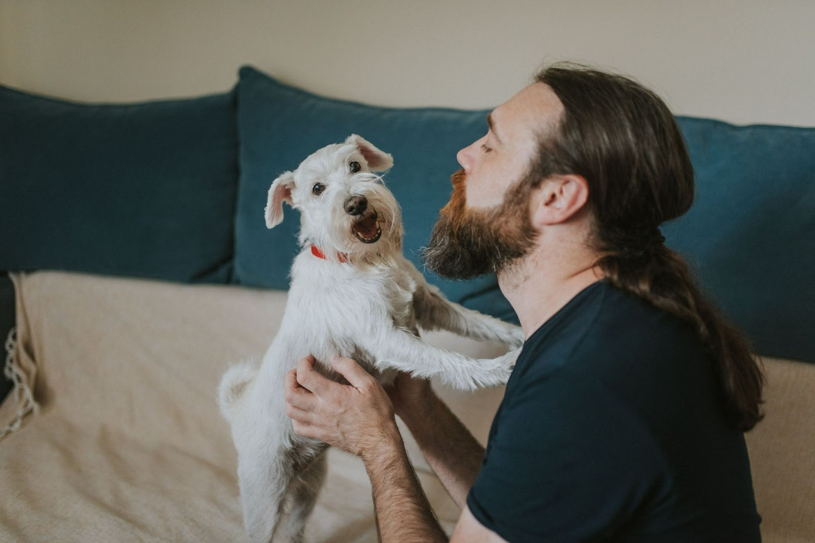 male with long hair spending time with his dog 