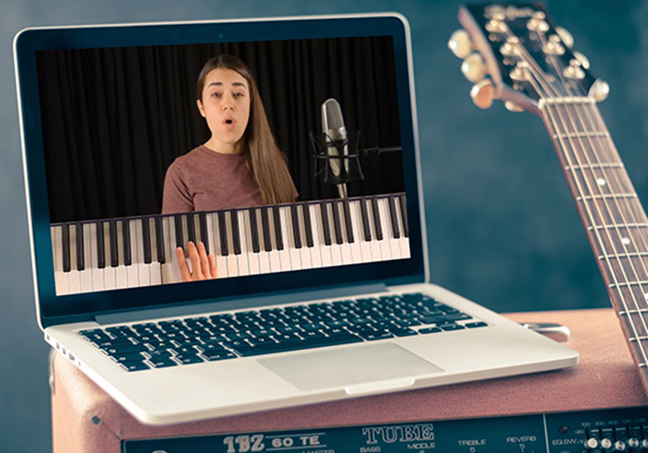 Lady singing on the laptop using online singing lessons.