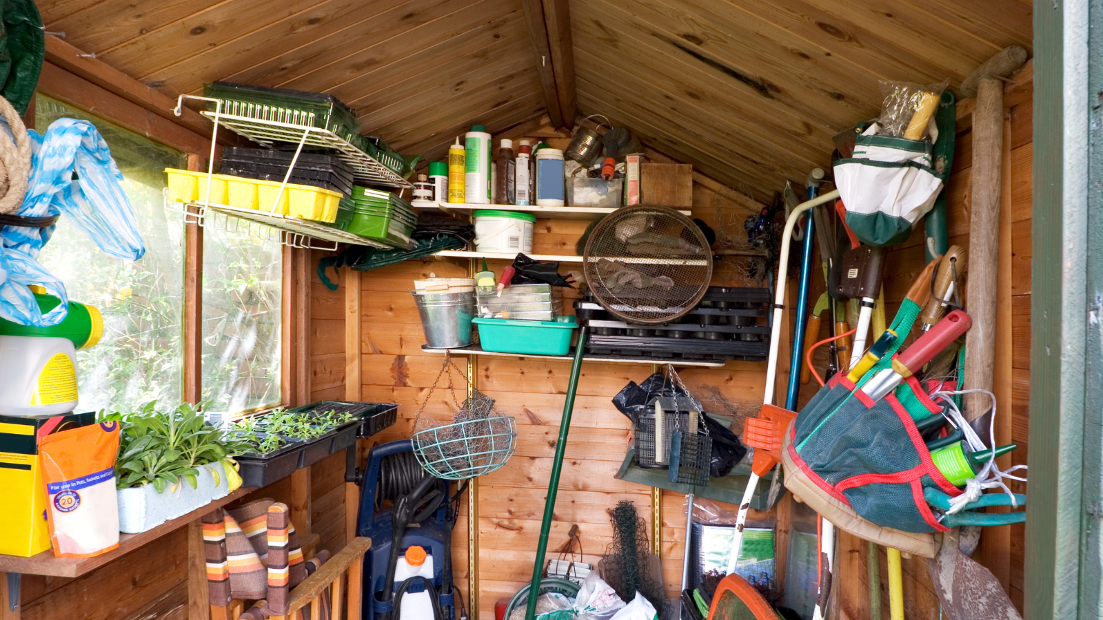Inside of a shed with tools, chairs and gardening equipment