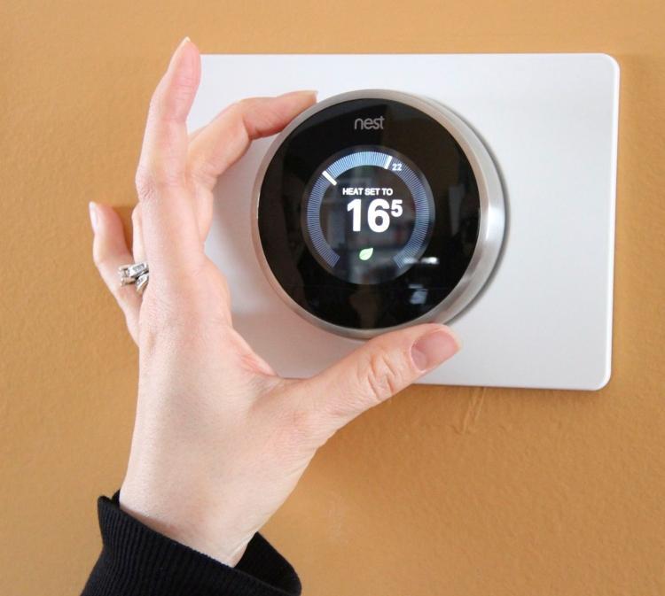 Woman\'s hand adjusting thermostat