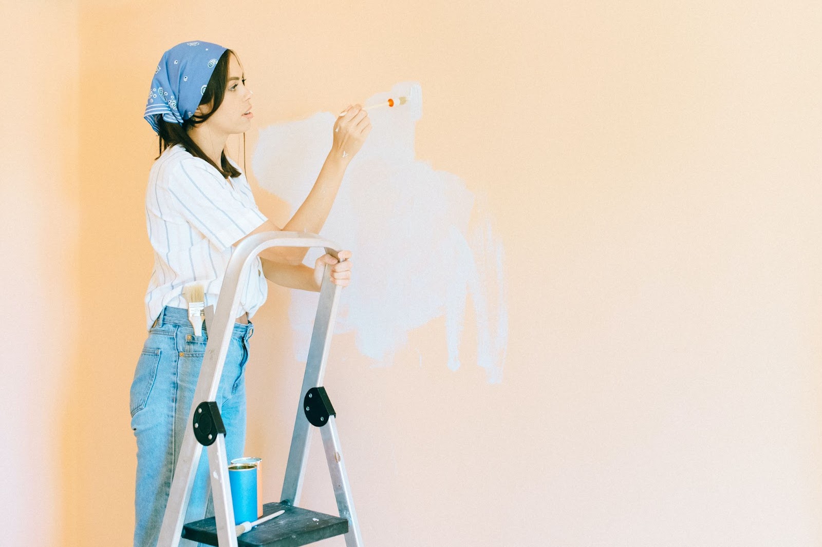 Woman painting on a step ladder, hire a professional 