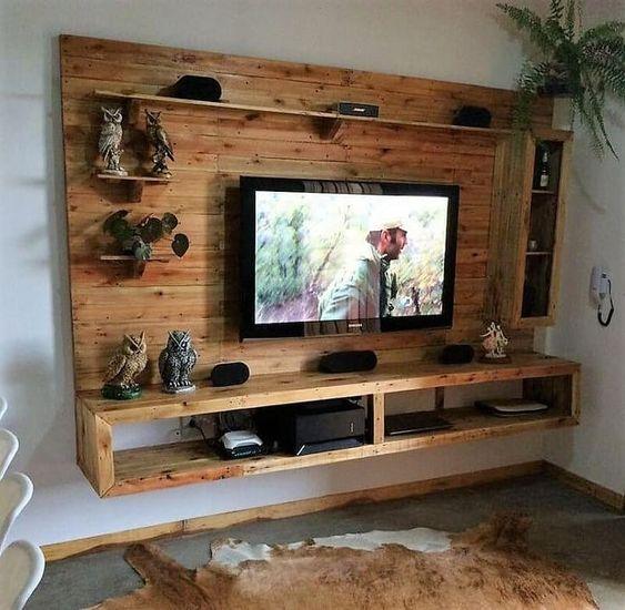 Ambiente com painel de TV de pallet que também serviu como uma pequena estante.