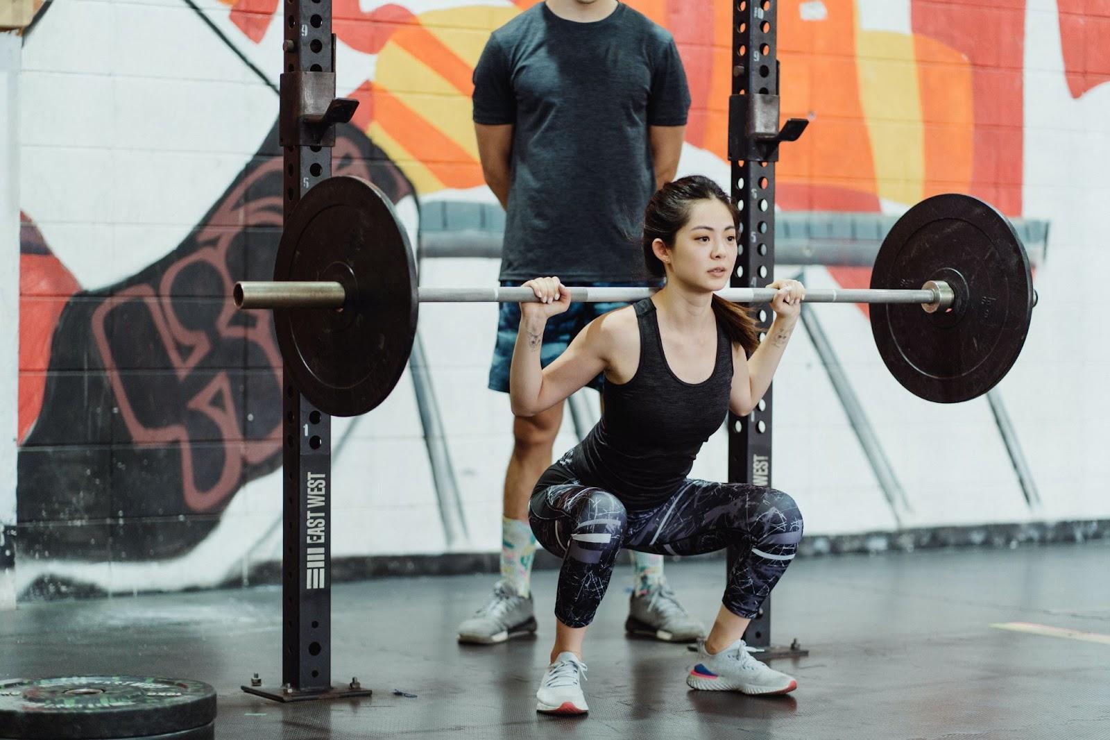 Woman Squatting with Barbell