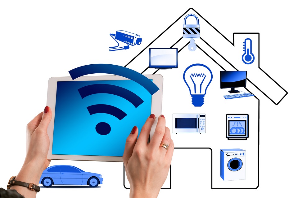 Womans hands holding a tablet with icon of a house behind it, showing images of devices that can be connected to Smart Homes.