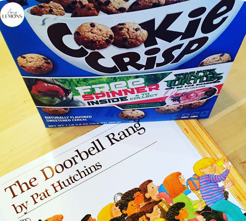 The book "The Doorbell Rang" with a box of cookie cereal.