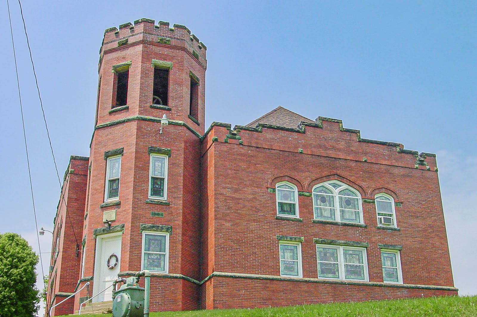 A red brick 3-story building with a round turret