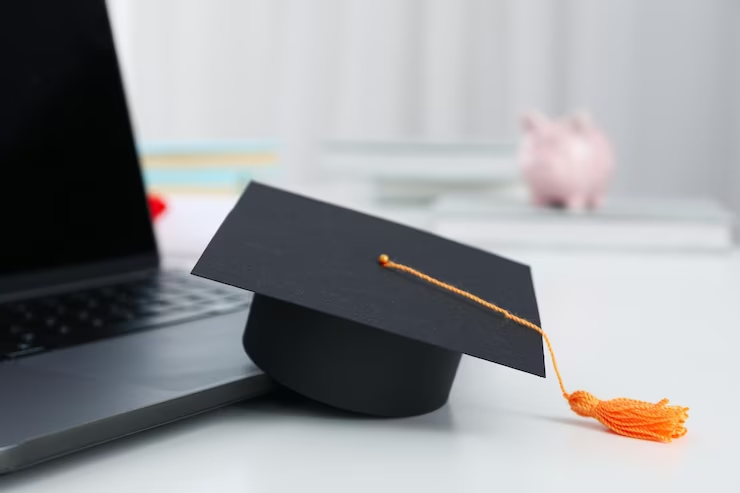 Graduation cap on desk with laptop, symbolising Final UCAT Results 2022.