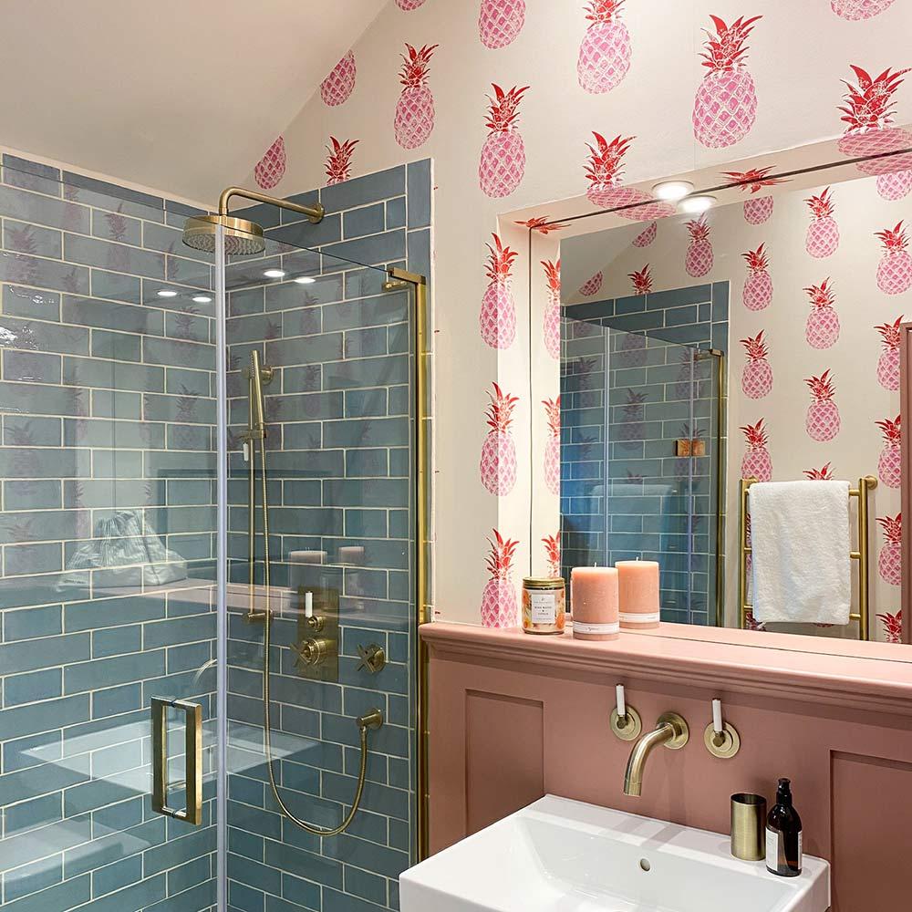 ورق جدران بطبعة الأناناس الوردي في الحمام مع دش مزين بالبلاط الفيروزي