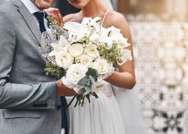 To beautiful beginnings Cropped shot of an unrecognizable bride and groom standing together flowers bouquet stock pictures, royalty-free photos & images