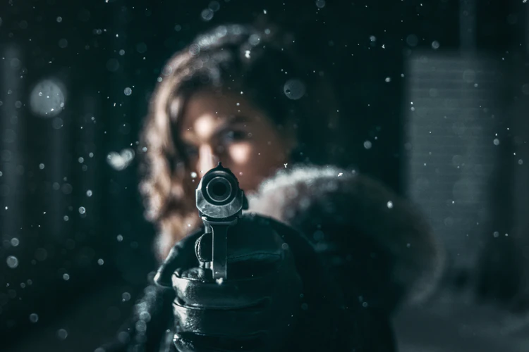 Woman aiming gun in light snow Northern Illinois Carry, LLC