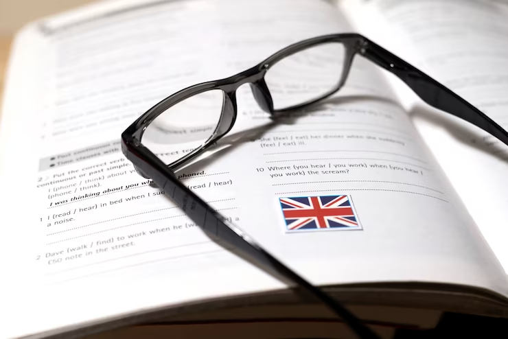Image of English book with glasses on a table, symbolizing educational preparation for UKiset-approved preparatory schools.