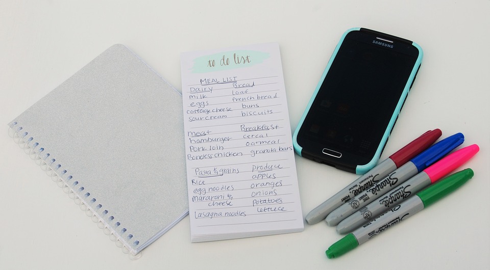 A to do list with notepad, mobile phone and Sharpies