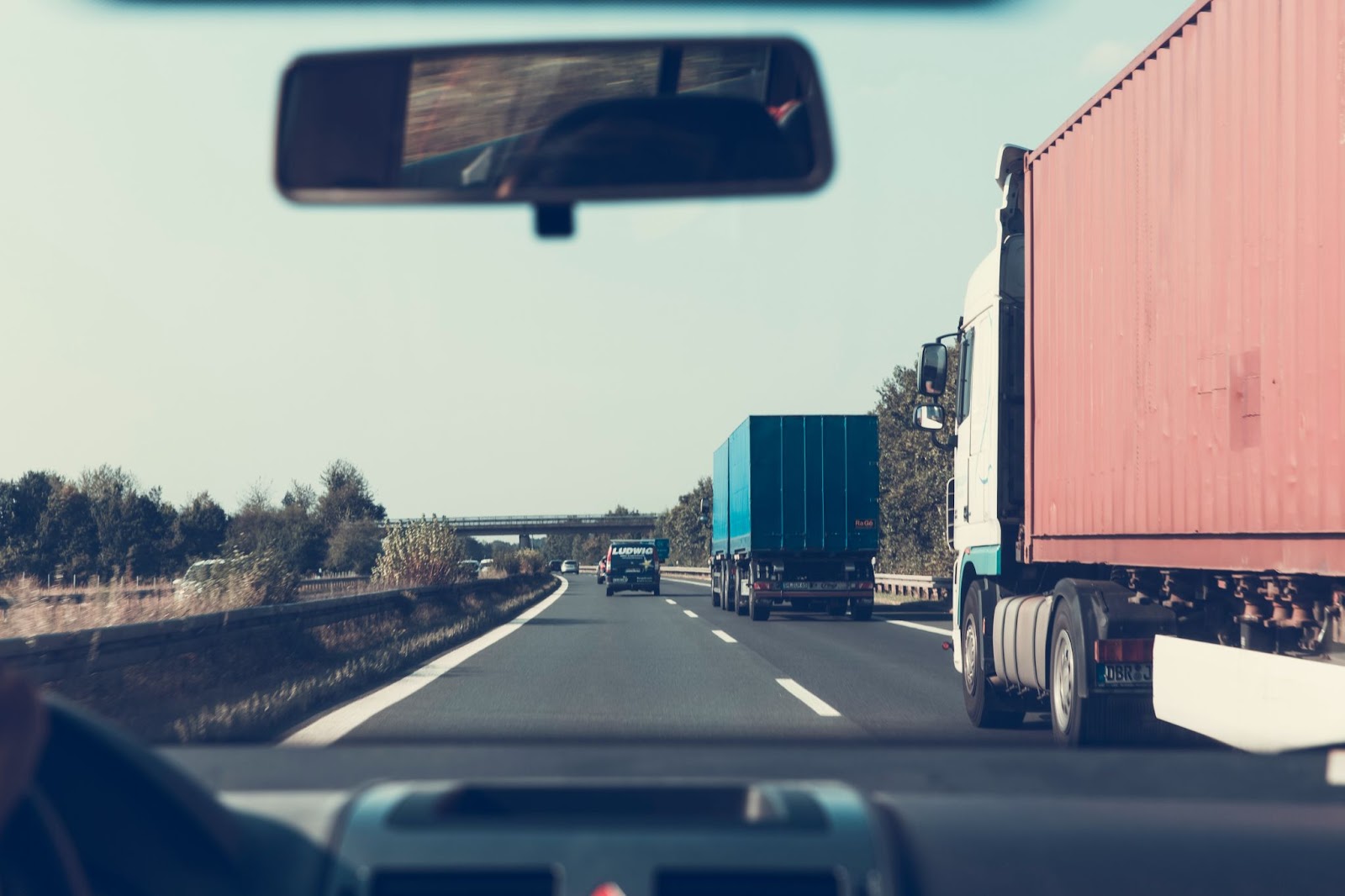 A picture of a highway road with trucks on it (from the perspective of the driver's seat)