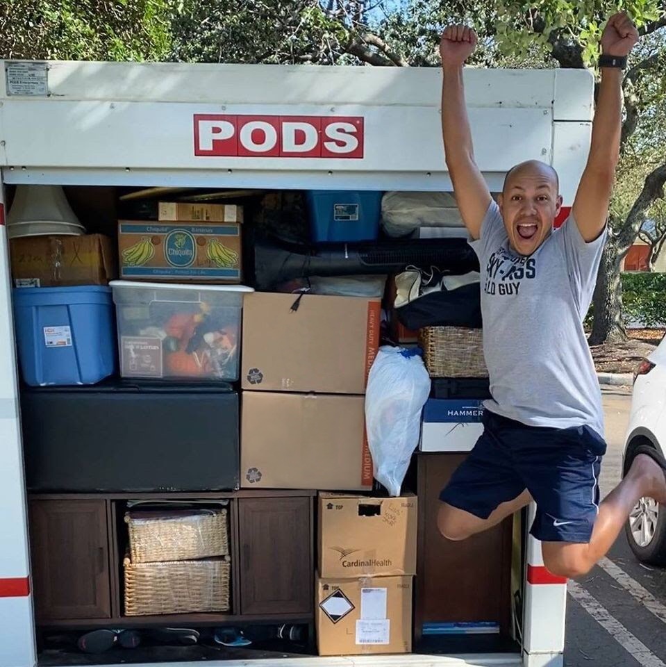 A happy PODS customer jumping with excitement in front of his well loaded portable container.